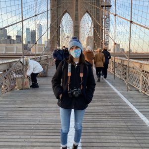 Photographer standing in the middle of the Brooklyn Bridge in New York City.